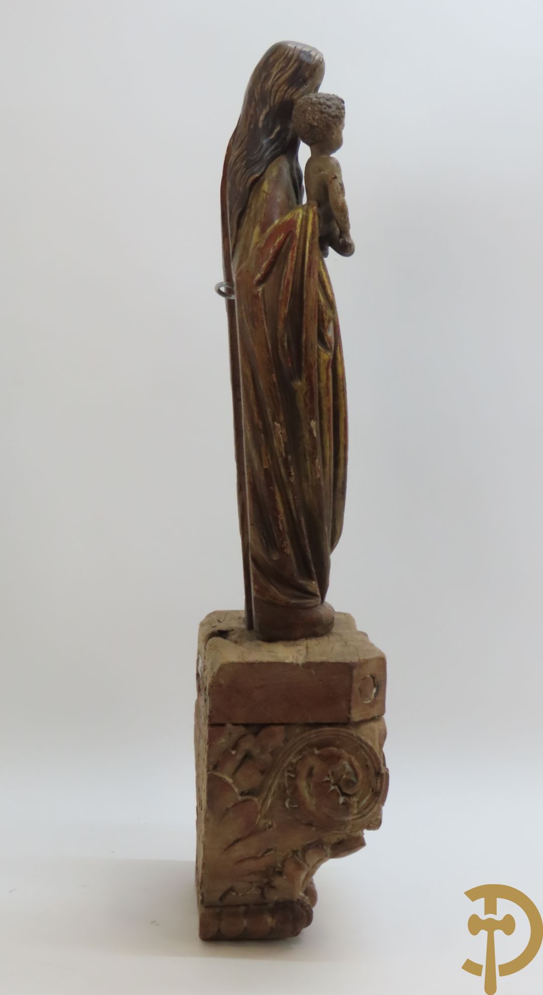 Gepolychromeerde houtsculptuur van madonna met kind gemonteerd op sokkel met accanthusranken