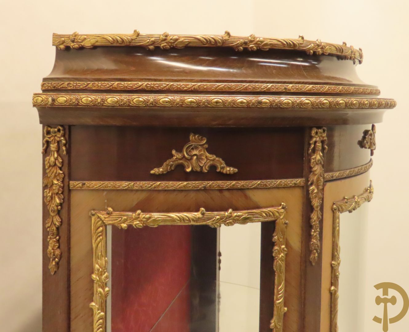 Gebogen notelaren vitrine met bronsbeslag en geanimeerd romantisch tafereel onderaan