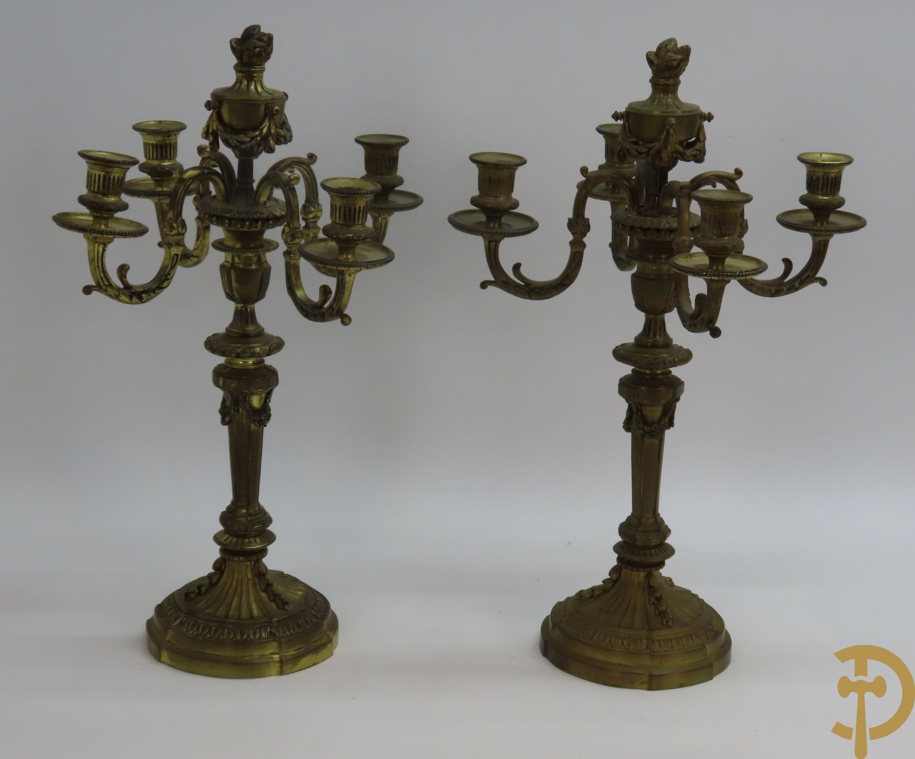 Paar bronzen Louis XVI vierarmige kandelaars bezet met toorts bovenaan