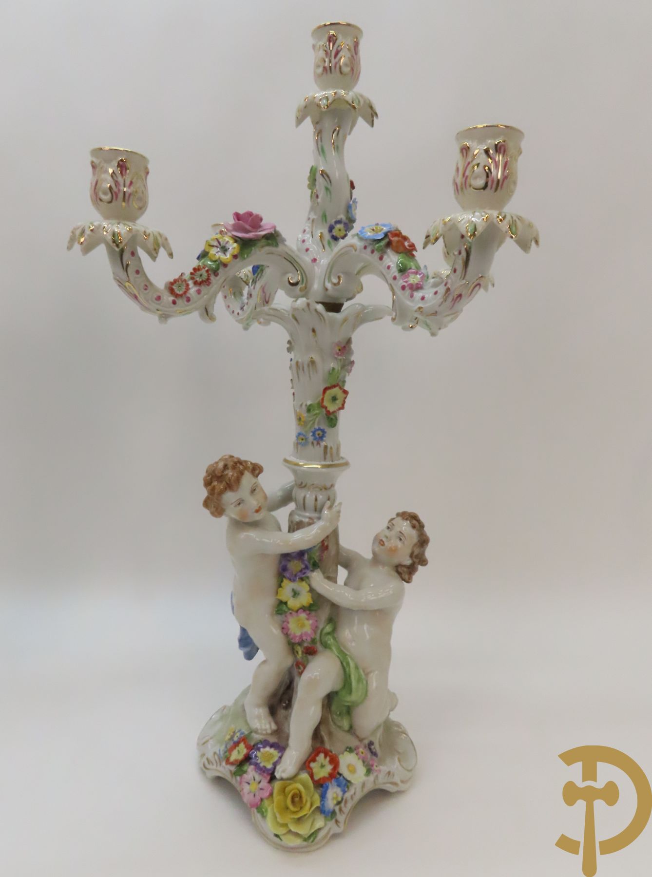 Twee porseleinen vijfarmige kandelaars met cupido