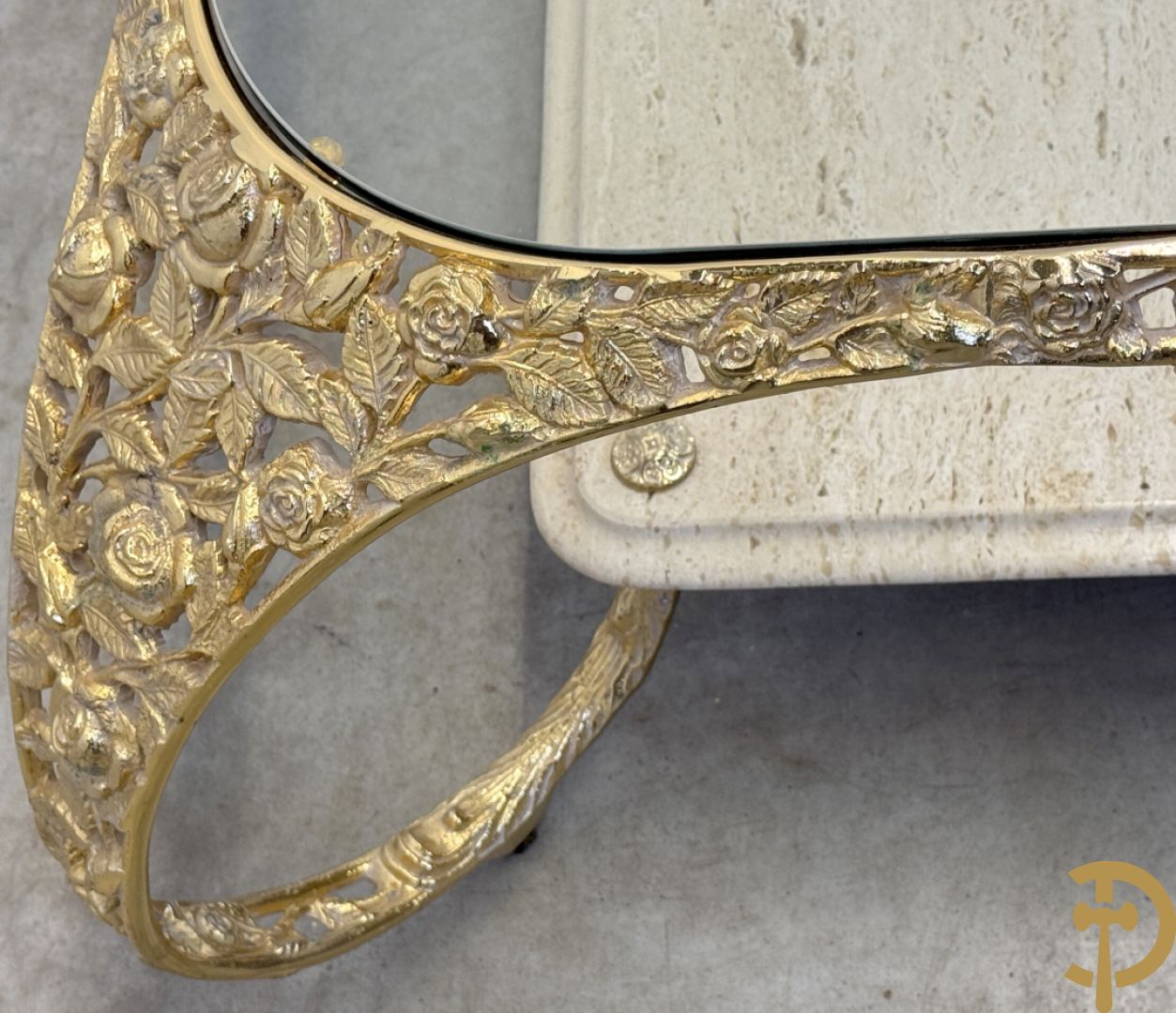 Salontafel met glazen blad op gebogen voluutvormige koperen poten gemaakt van bladranken - onderaan met travertin blad