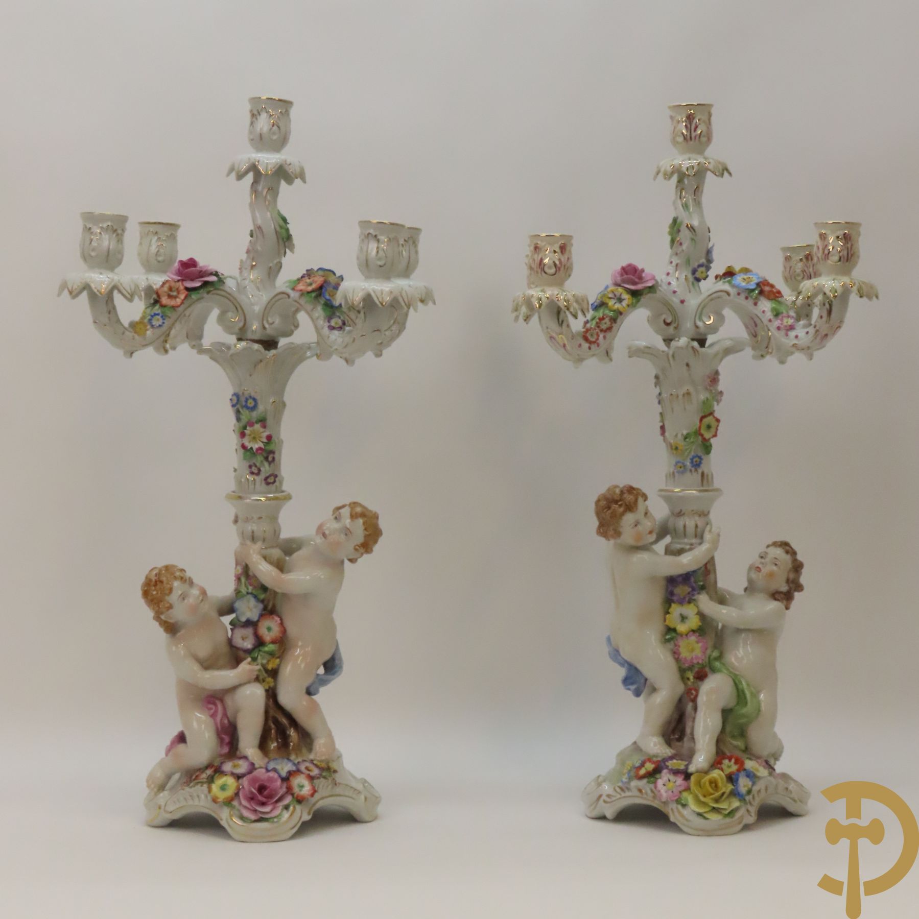 Twee porseleinen vijfarmige kandelaars met cupido