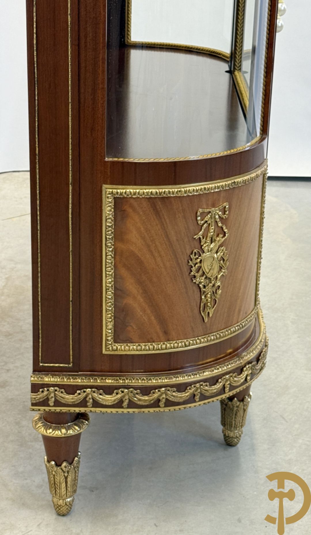 Notelaren vitrine met afgeronde zijkanten, bezet met bronzen plakkettes van dame en cupido