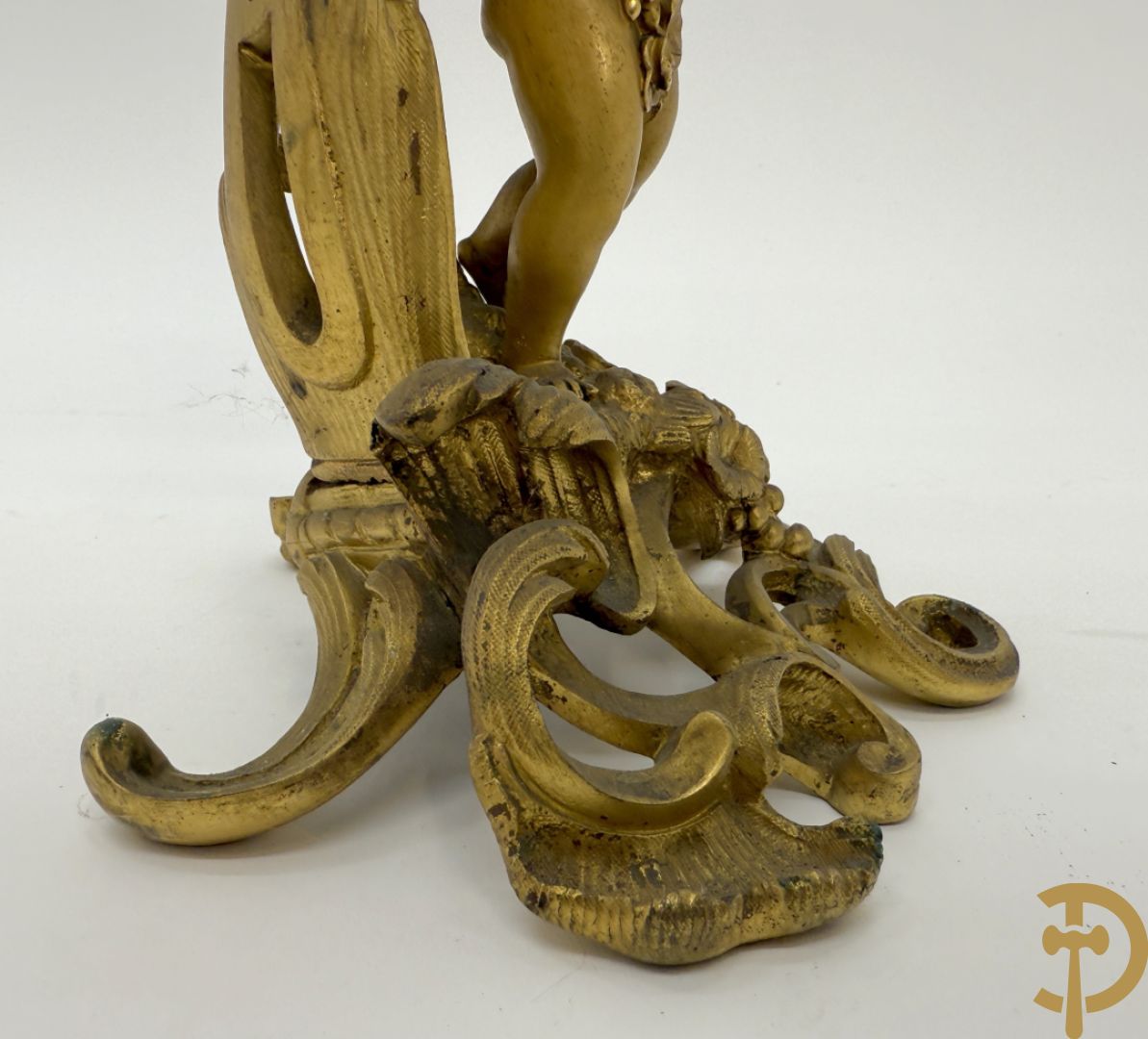 Driedelige vuurvergulde bronzen garnituur, Louis XV stijl, bestaande uit middenstuk met klok omgeven door musicerende cupido