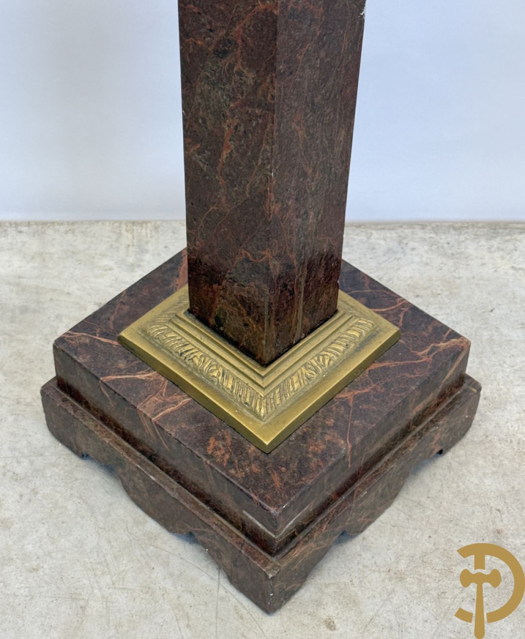 Bruin geaderde marmeren zuil met bronzen ornamenten