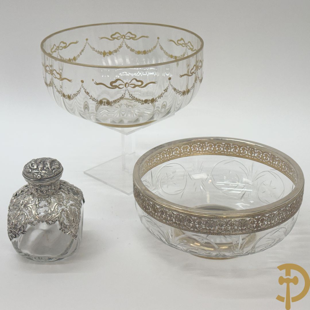 Kristallen flacon met verzilverd omhulsel en geanimeerd tafereel + kristallen coupe met verzilverde rand + kristallen coupe met vergulde louis XVI strikken en guirlandes