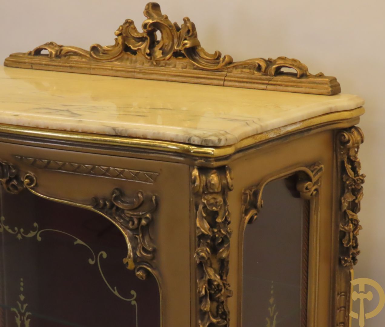 Vergulde vitrine met accanthusranken en ornamentiek in de ruiten geslepen, bovenaan bezet met marmeren blad