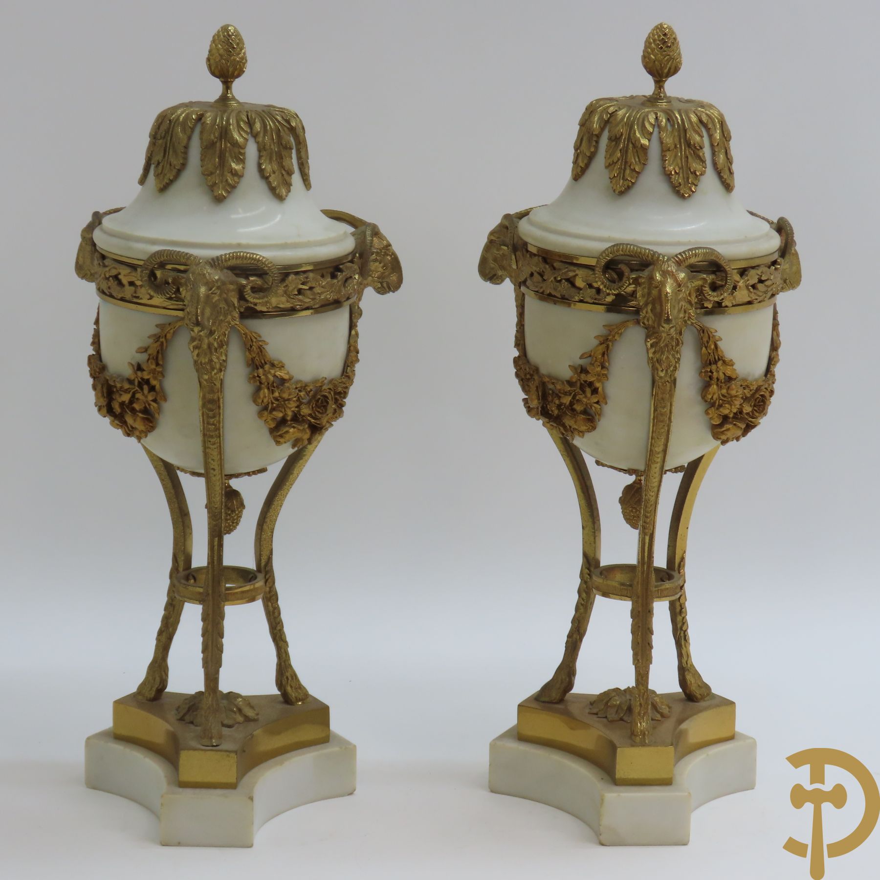 Paar marmeren cassolettes met ramskopen bezet, dragende 3 bloemenguirlandes - bovenaan bezet met denappel