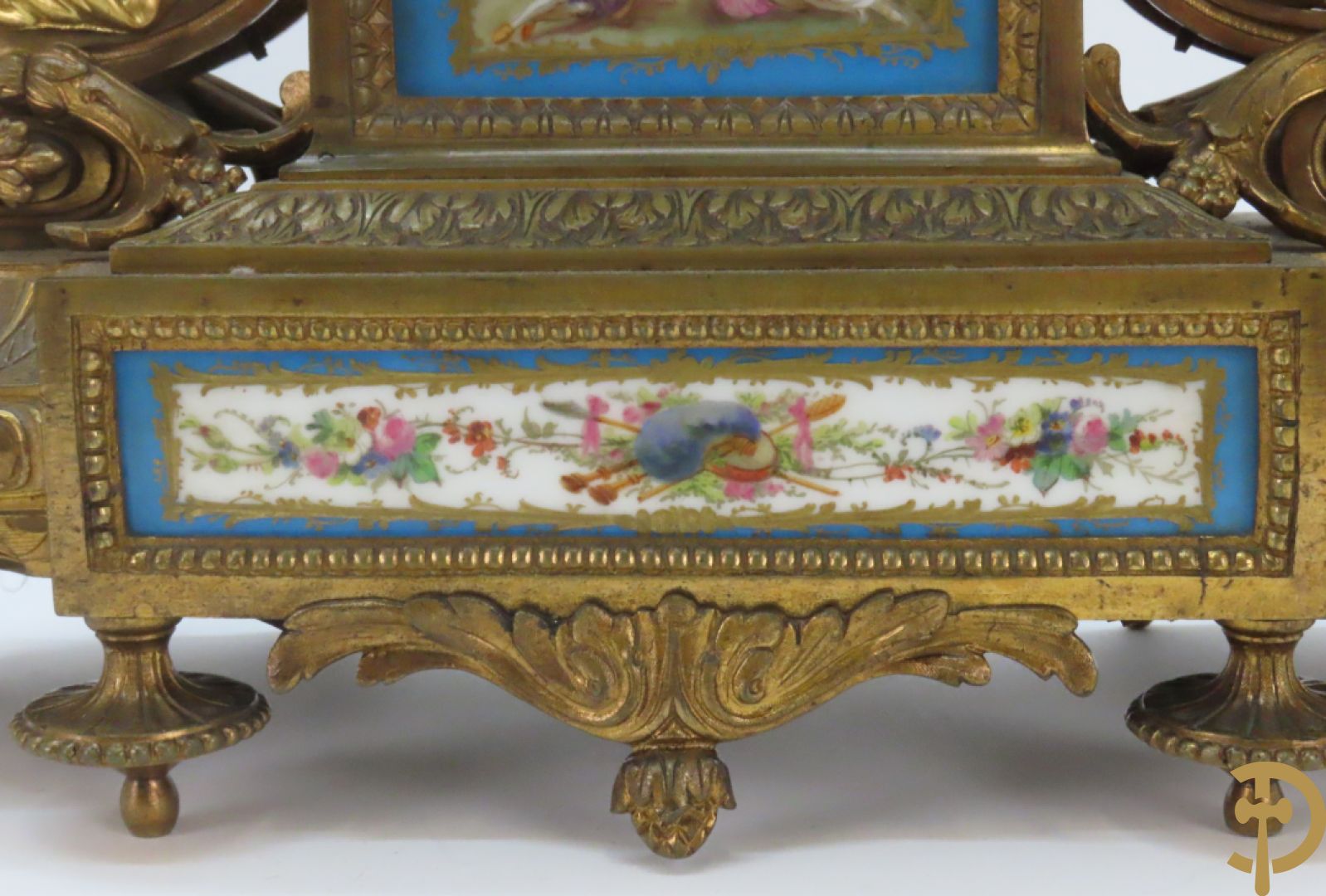 Driedelige bronzen garnituur bezet met Sèvres porselein bestaande uit pendule geflankeerd door paar cupido