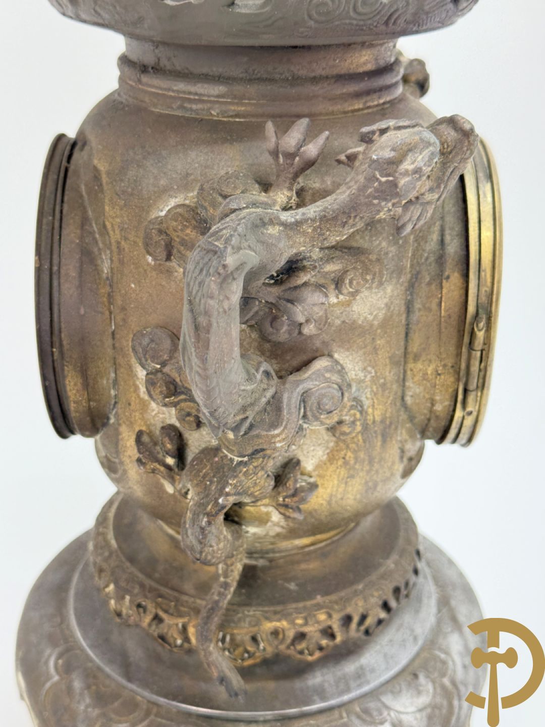 Aziatische pendule in zamak, zijdelings bezet met drakendecor en bovenaan met mythologisch figuur