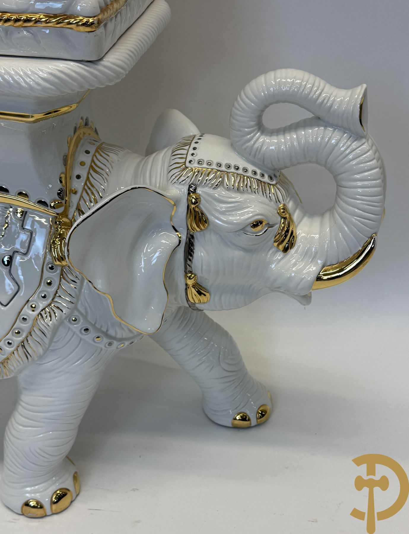 Porseleinen sierbeeld van olifant als staander met daarboven jongeman met bloemencachepot