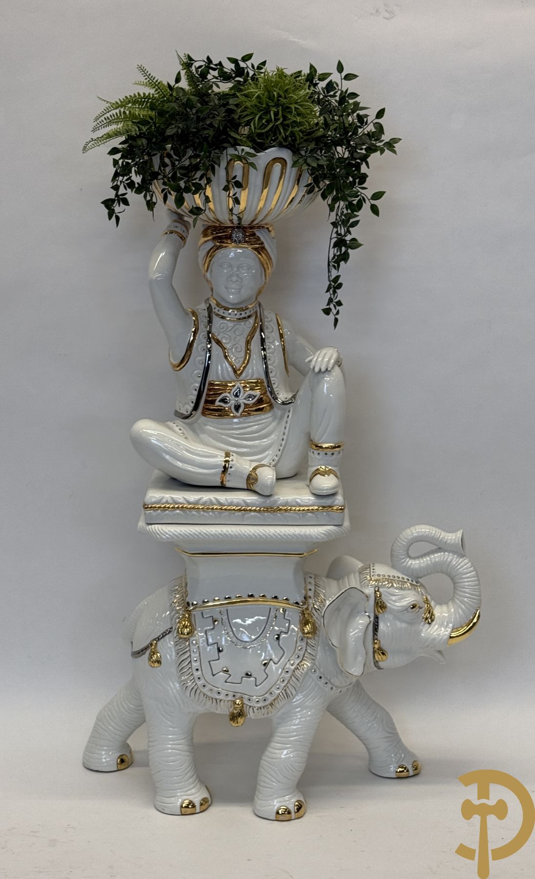 Porseleinen sierbeeld van olifant als staander met daarboven jongeman met bloemencachepot