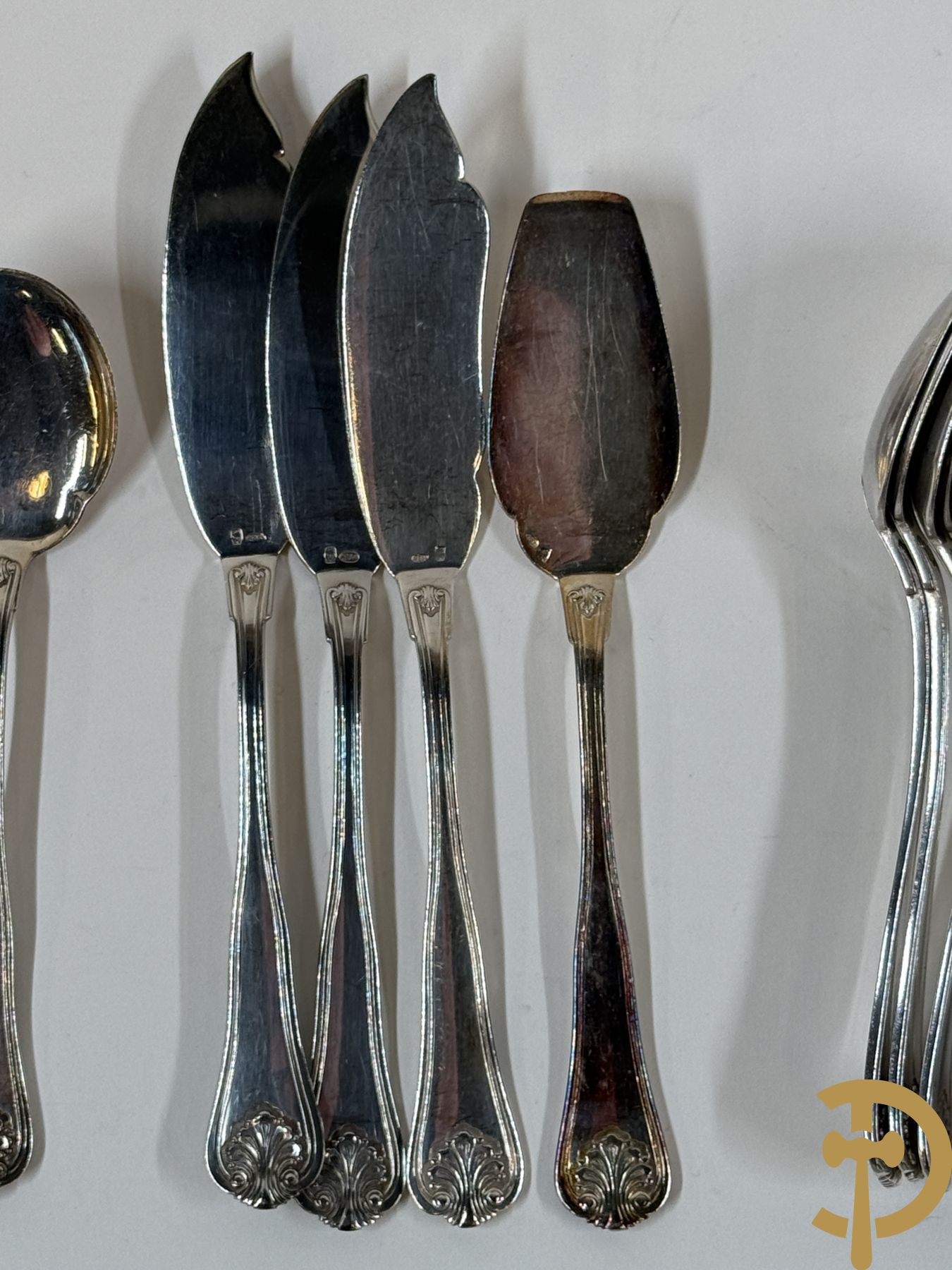 Massief zilveren bestek Wolfers bestaande uit 12 vorken (979 gram), 12 lepels (1028 gram), 11 messen, 12 visvorken (553 gram), 12 vismessen (690 gram), 12 dessertmessen, 10 koffielepels (296 gram), 12 ijslepels (369 gram), 3 botermesjes en scheplepeltje (165 gram), 5  grote stukken (samen 557 gram) waarvan slacouvert, 2 taartscheppen en wildvork + sauslepel met zelfde decor maar Metal Blanc