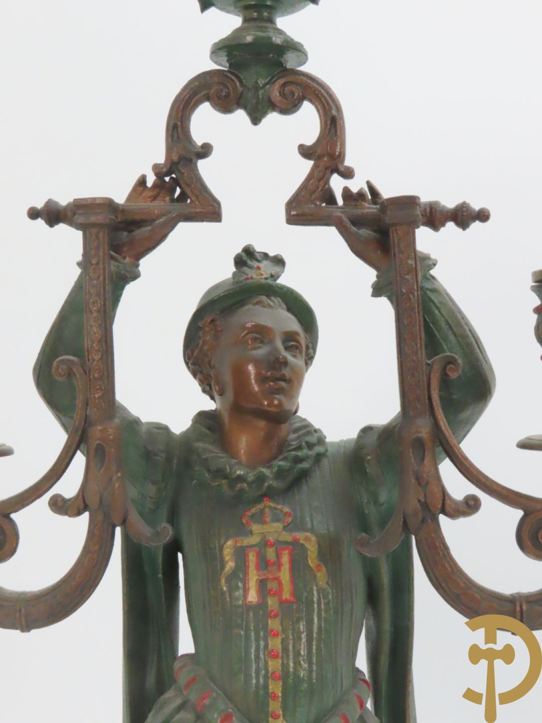 Driedelige kunstbronzen garnituur bestaande uit pendule met paar schakende edelheren, bezet met kariatiden - geflankeerd door paar driearmige kandelaars gehouden door 2 edelheren