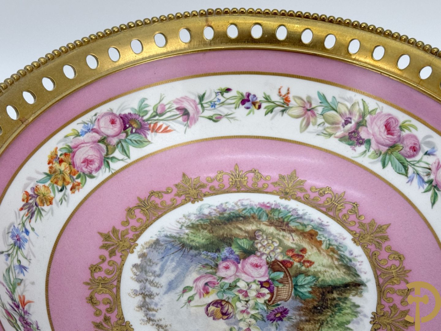 Porseleinen coupe met centraal tafereel en omringd met bloemendecor, gevat in bronzen houder