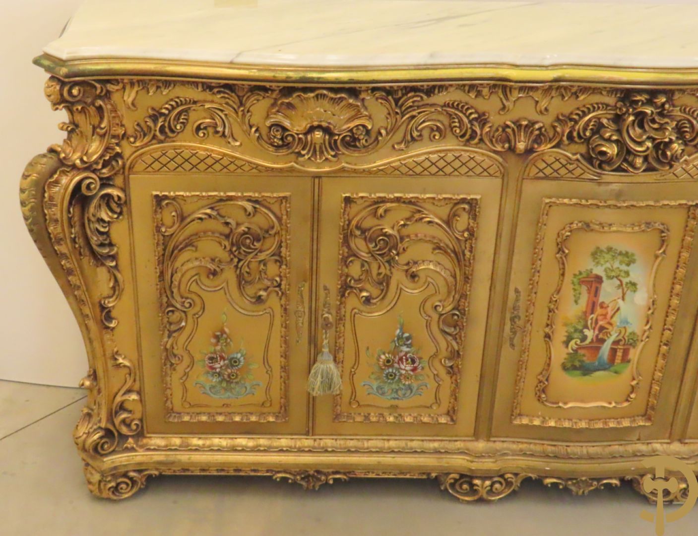 Uitzonderlijke vergulde Louis XV eetkamer bestaande uit vijfdeursdressoir met voluutvormige accanthusranken en rocailles, beschilderd met bloemenmotieven en centraal tafererel met hoornen des overvloeds + bijhorende spiegel vergulde tafel op voluutvormige poten met zes bijhorende stoelen + vitrine met accanthusranken en centrale deur, op voluutvormige poten