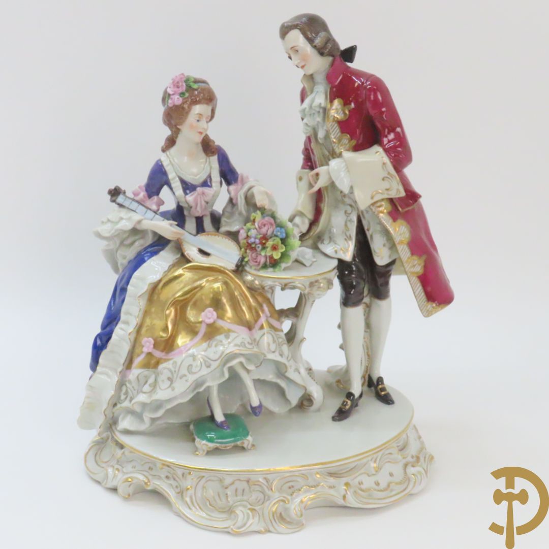 Porseleinen groep met zittende dame bij mandoline en heer met boeket bloemen, achteraan gemerkt Sax