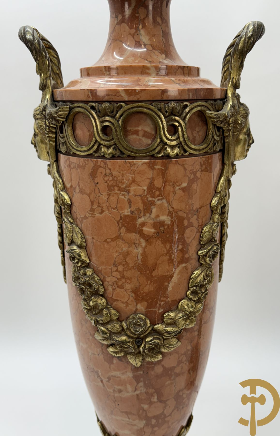 Paar oranje/rode marmeren cassolettes, zijdelings bezet met dameshoofden dragende een guirlande van bloemen - bovenaan met bloementroffee