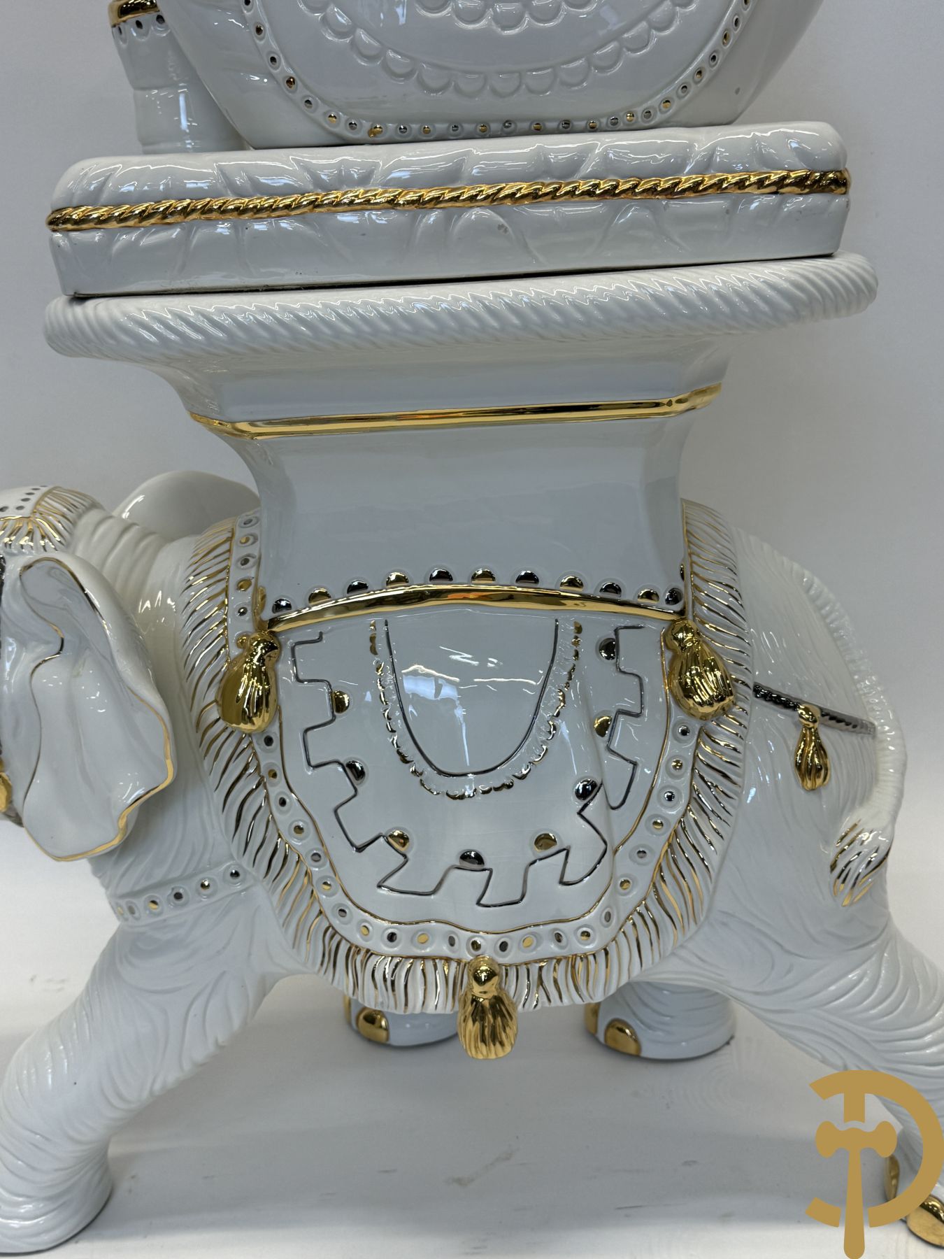 Porseleinen sierbeeld van olifant als staander met daarboven jongeman met bloemencachepot