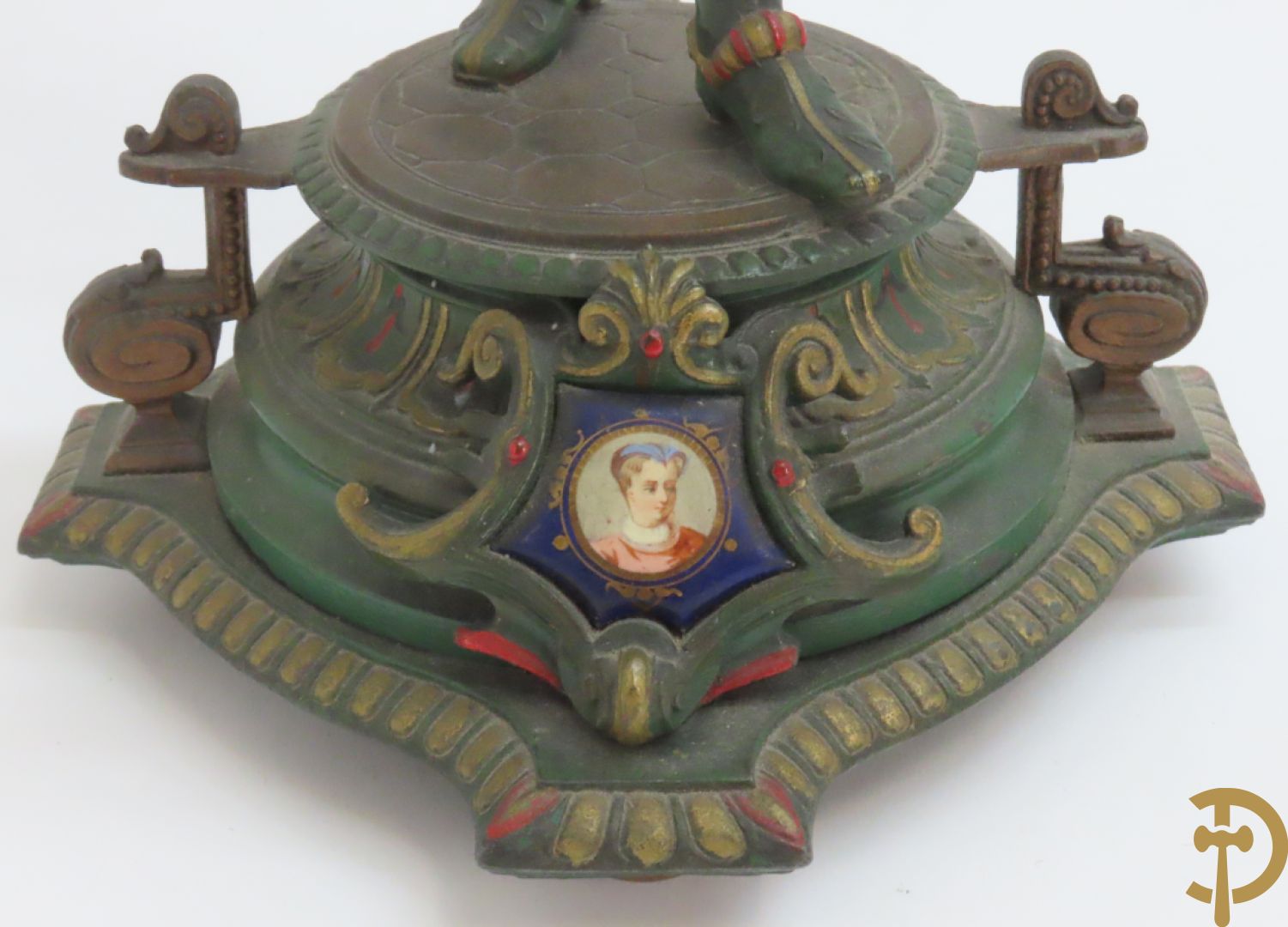 Driedelige kunstbronzen garnituur bestaande uit pendule met paar schakende edelheren, bezet met kariatiden - geflankeerd door paar driearmige kandelaars gehouden door 2 edelheren