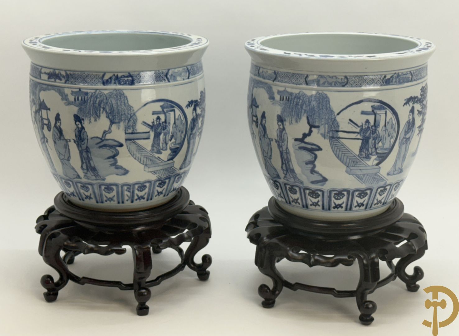 Twee blauw/witte cachepots met geanimeerd landschapsdecor op houten sokkels