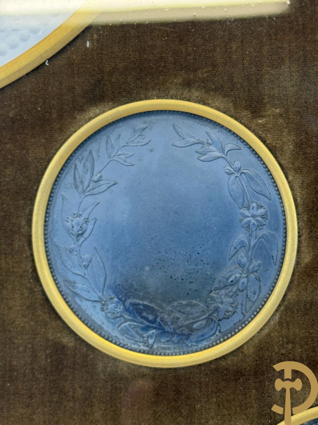 Kader met twee porseleinen plakkettes en 3 munten van Oudiné Eugène André