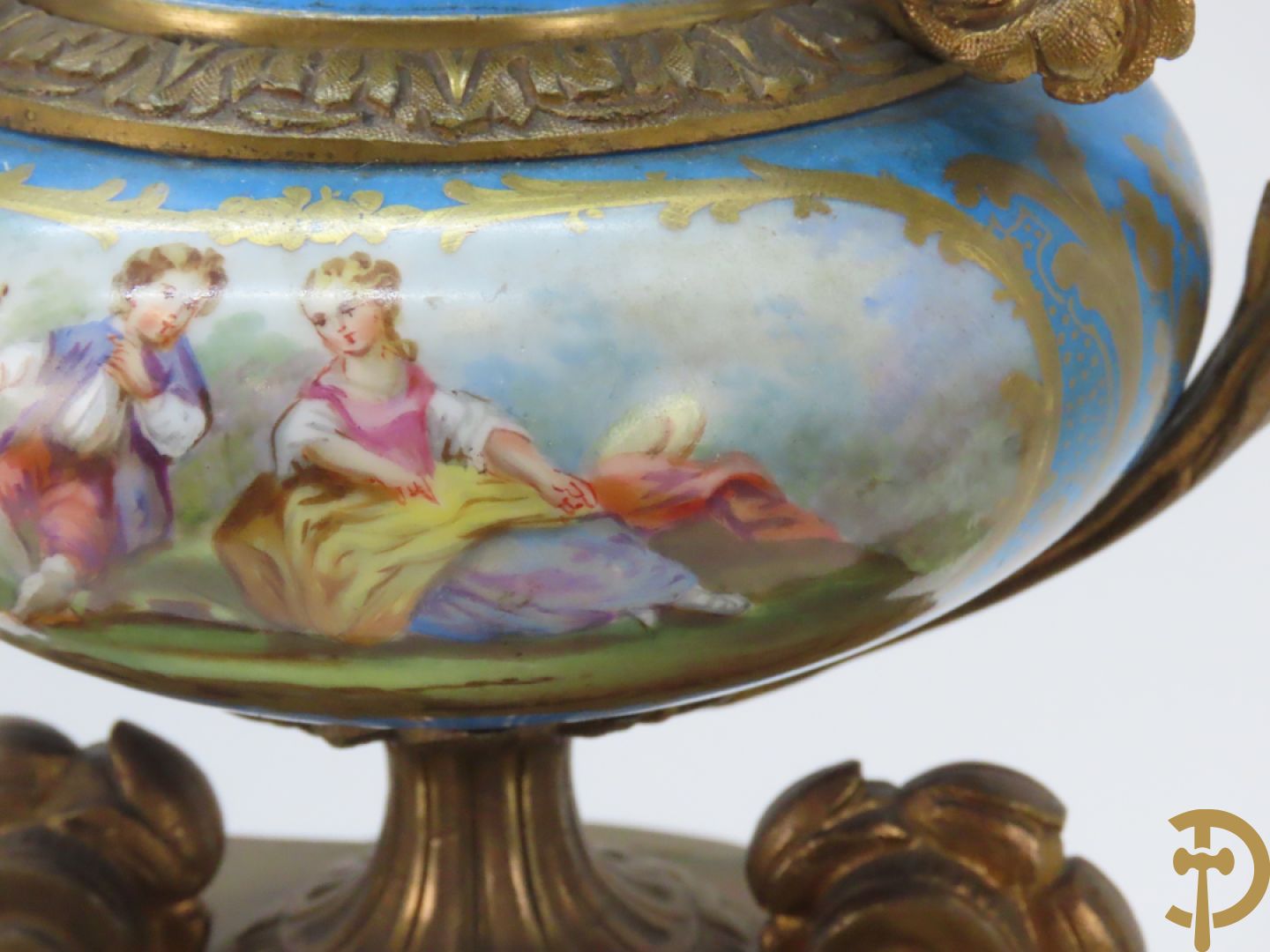 Driedelige bronzen garnituur bezet met Sèvres porselein bestaande uit pendule geflankeerd door paar cupido