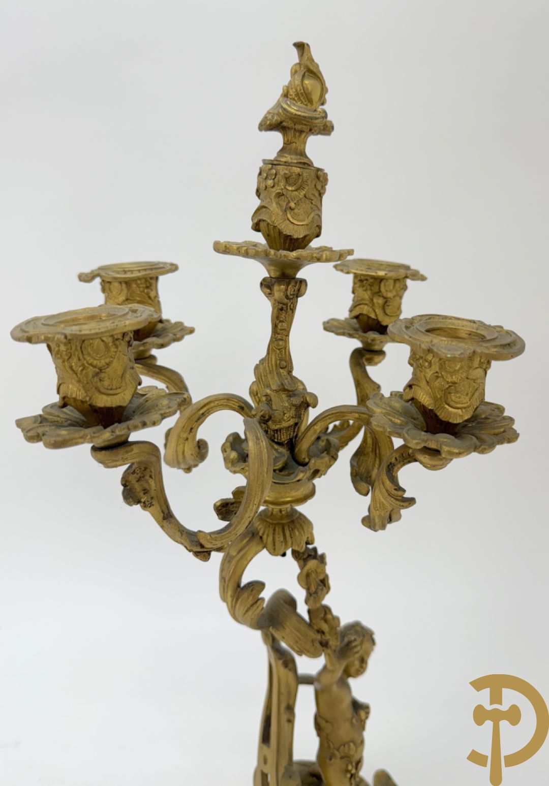 Driedelige vuurvergulde bronzen garnituur, Louis XV stijl, bestaande uit middenstuk met klok omgeven door musicerende cupido