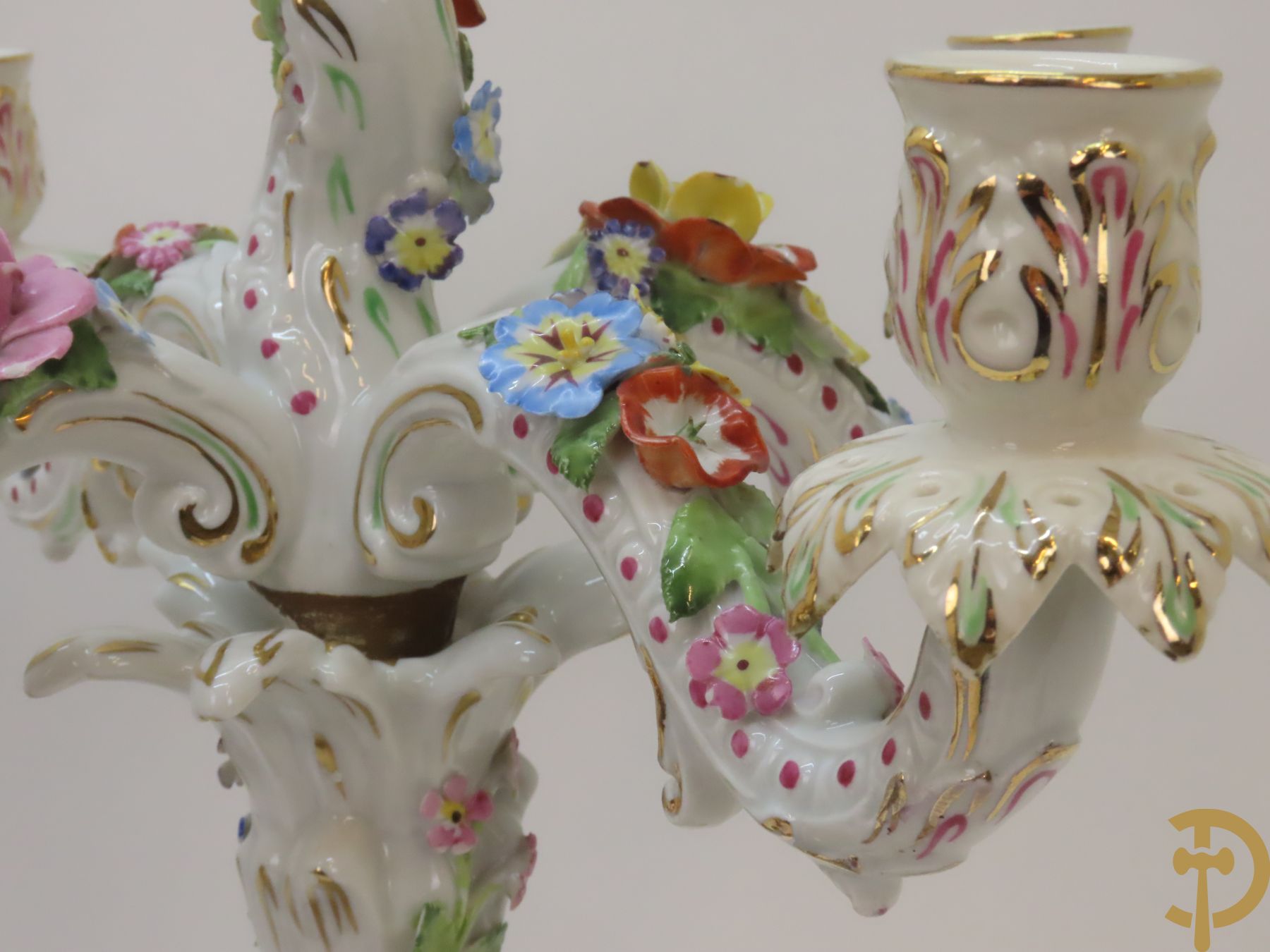 Twee porseleinen vijfarmige kandelaars met cupido