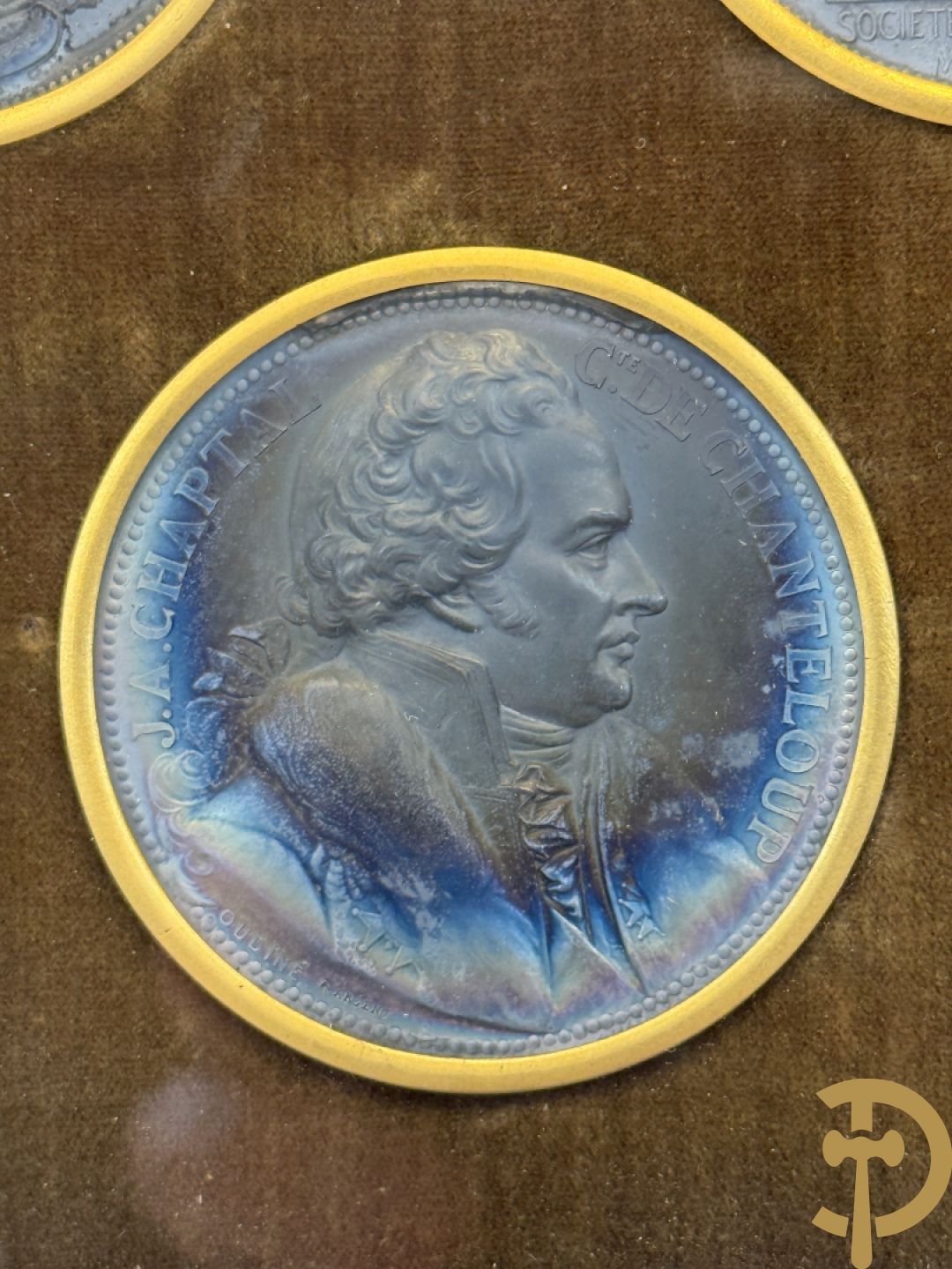 Kader met twee porseleinen plakkettes en 3 munten van Oudiné Eugène André