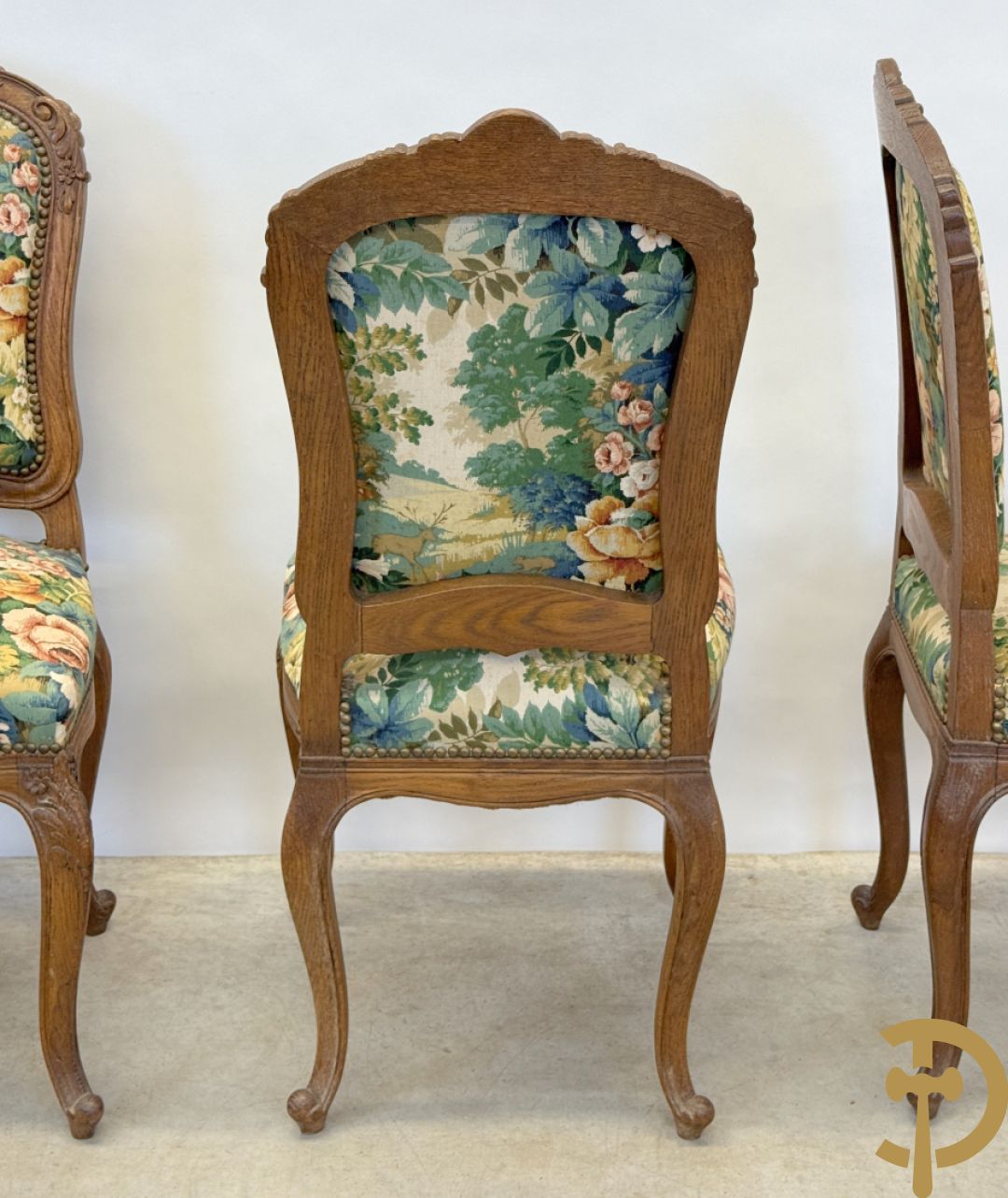Vier eiken Louis XV stoelen met gebloemde stof en rocailles in de rug, op voluutvormige poten