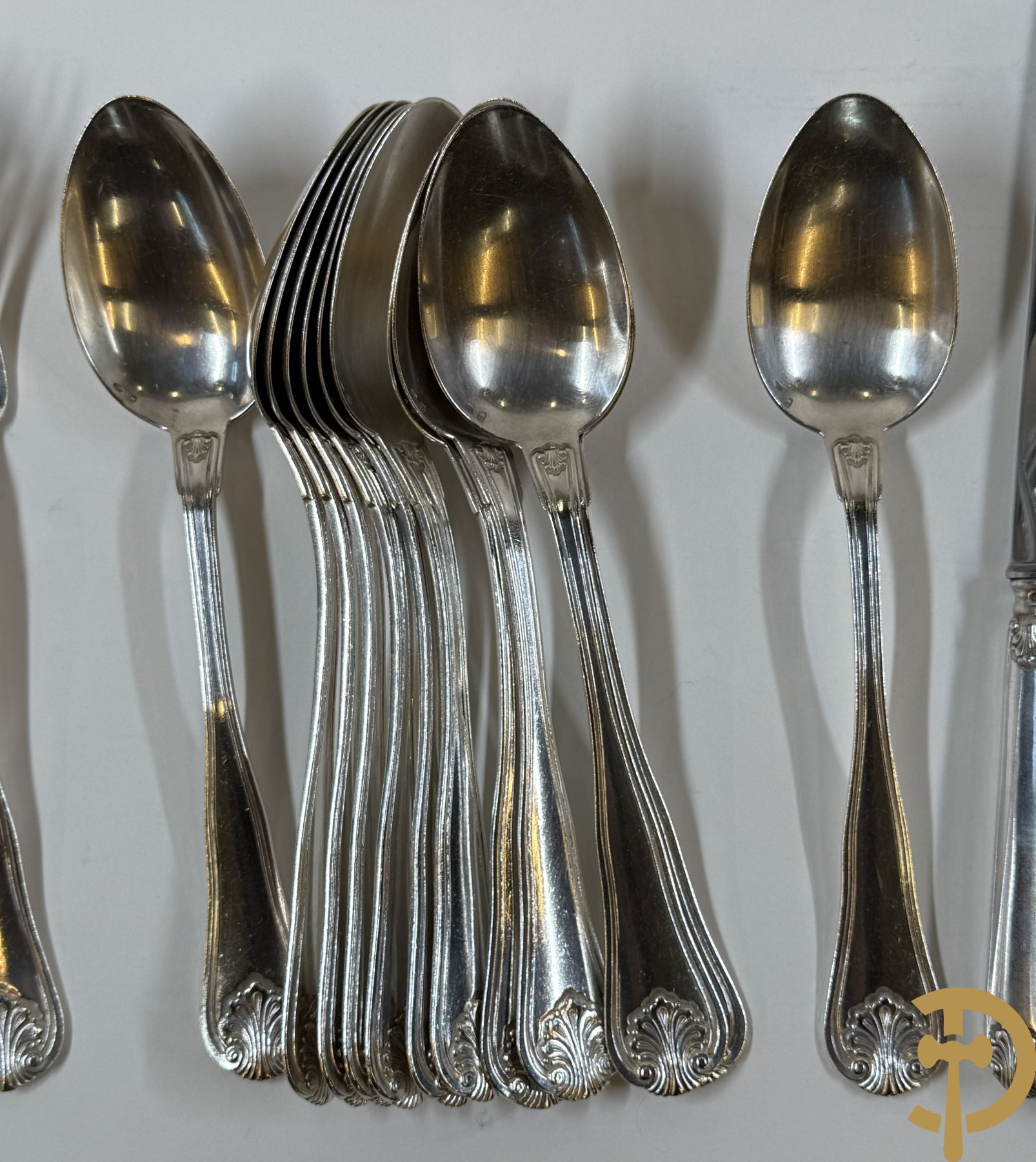 Massief zilveren bestek Wolfers bestaande uit 12 vorken (979 gram), 12 lepels (1028 gram), 11 messen, 12 visvorken (553 gram), 12 vismessen (690 gram), 12 dessertmessen, 10 koffielepels (296 gram), 12 ijslepels (369 gram), 3 botermesjes en scheplepeltje (165 gram), 5  grote stukken (samen 557 gram) waarvan slacouvert, 2 taartscheppen en wildvork + sauslepel met zelfde decor maar Metal Blanc