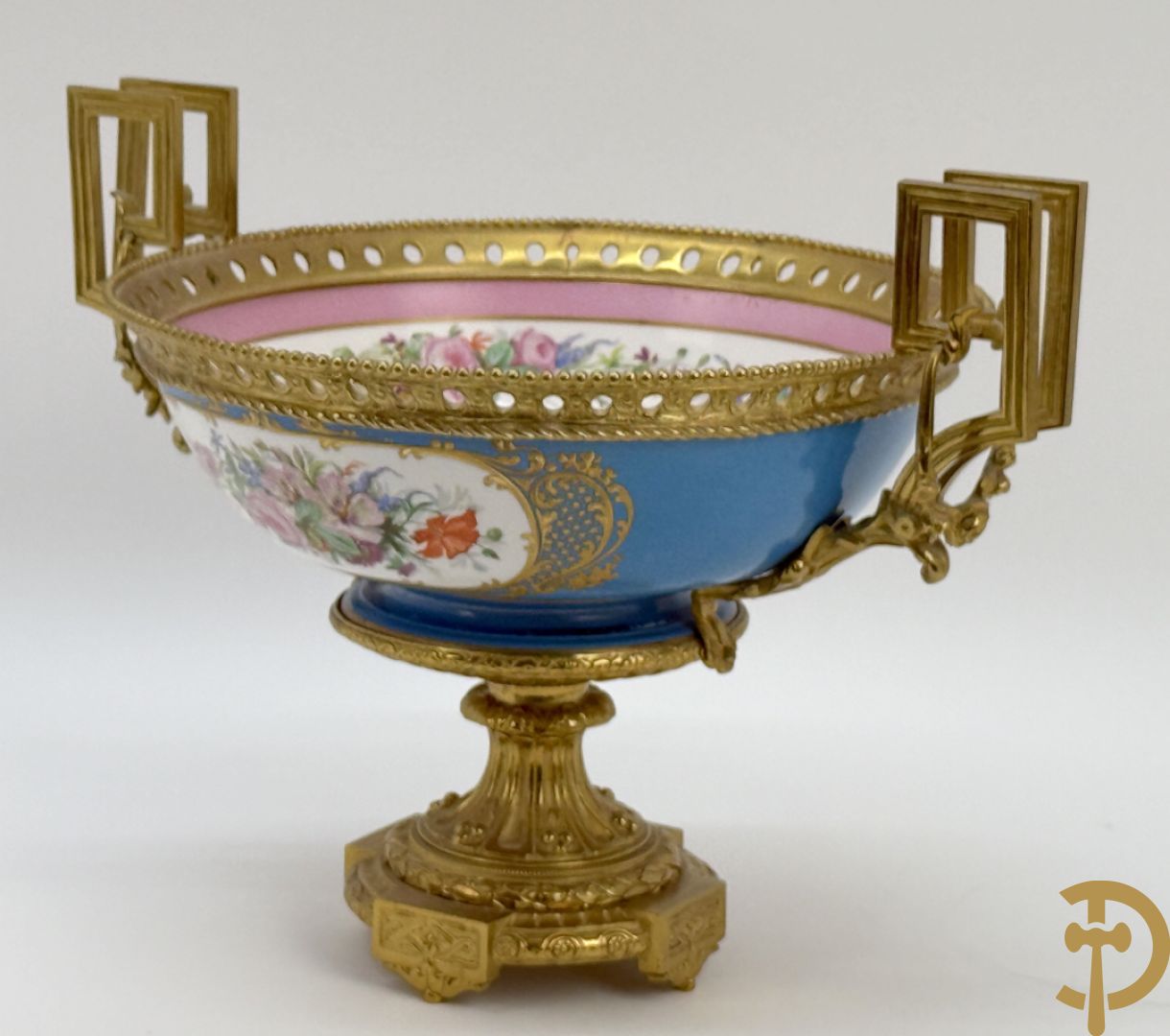 Porseleinen coupe met centraal tafereel en omringd met bloemendecor, gevat in bronzen houder