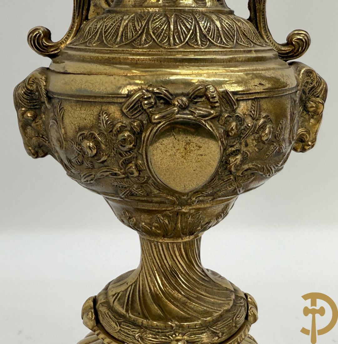 Paar koperen cassolettes bezet met ramskoppen dragende een cupido + koperen beeld van jongeman met zevenarmige kandelaar