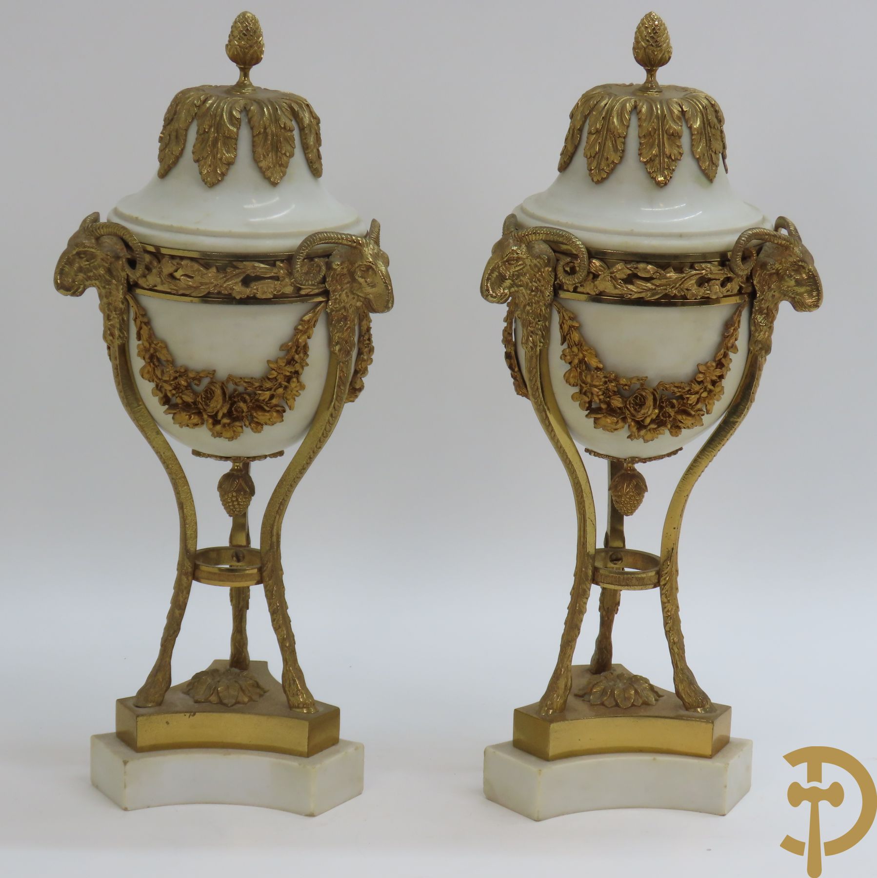 Paar marmeren cassolettes met ramskopen bezet, dragende 3 bloemenguirlandes - bovenaan bezet met denappel