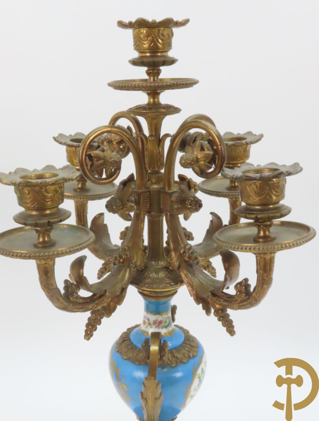 Driedelige bronzen garnituur bezet met Sèvres porselein bestaande uit pendule geflankeerd door paar cupido