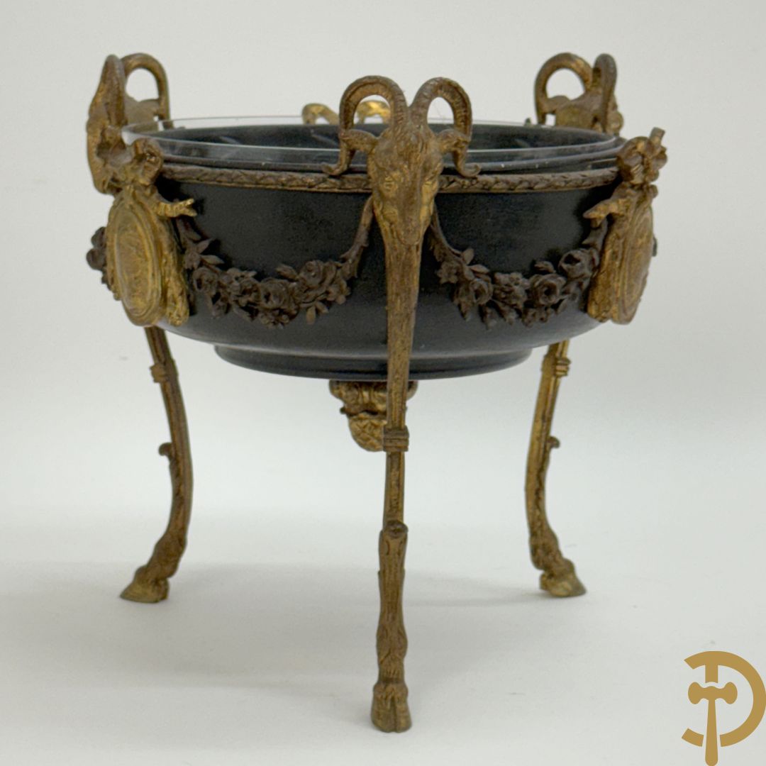 Bronzen coupe op 3 bokkepoten met ramskoppen  bezet en verbonden door guirlandes met medaillon