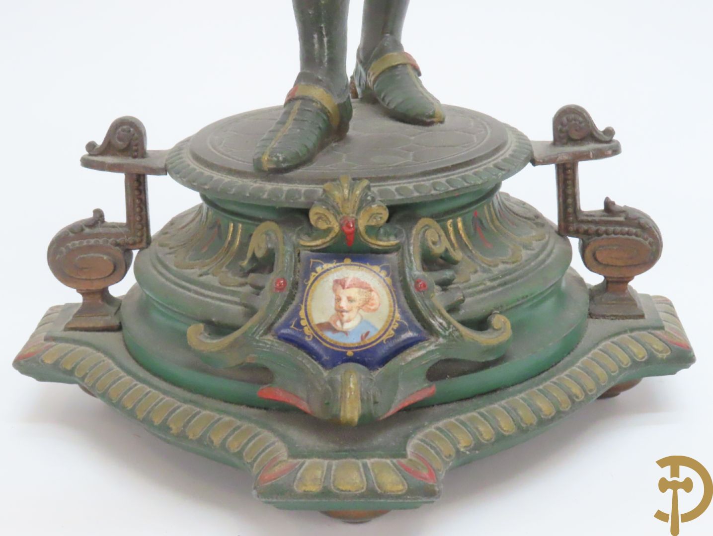 Driedelige kunstbronzen garnituur bestaande uit pendule met paar schakende edelheren, bezet met kariatiden - geflankeerd door paar driearmige kandelaars gehouden door 2 edelheren