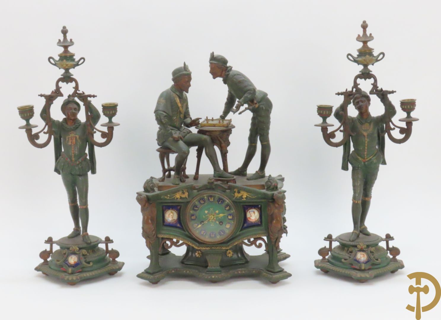 Driedelige kunstbronzen garnituur bestaande uit pendule met paar schakende edelheren, bezet met kariatiden - geflankeerd door paar driearmige kandelaars gehouden door 2 edelheren