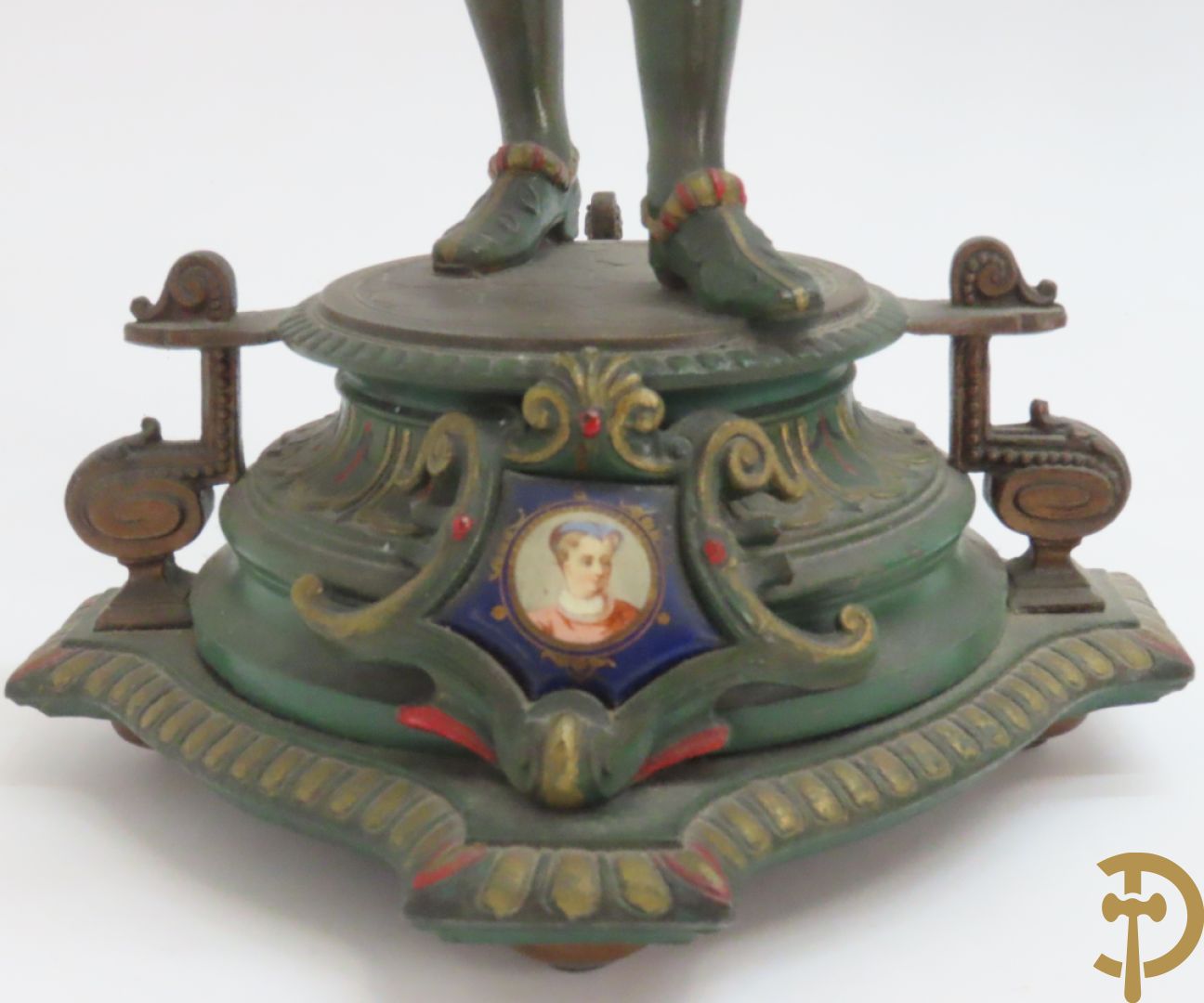 Driedelige kunstbronzen garnituur bestaande uit pendule met paar schakende edelheren, bezet met kariatiden - geflankeerd door paar driearmige kandelaars gehouden door 2 edelheren