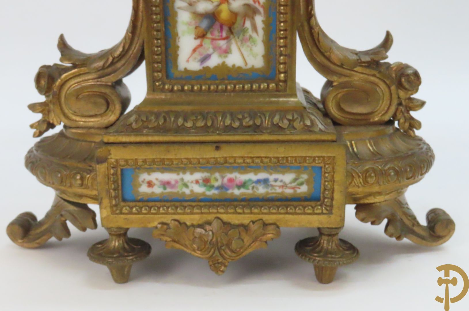 Driedelige bronzen garnituur bezet met Sèvres porselein bestaande uit pendule geflankeerd door paar cupido