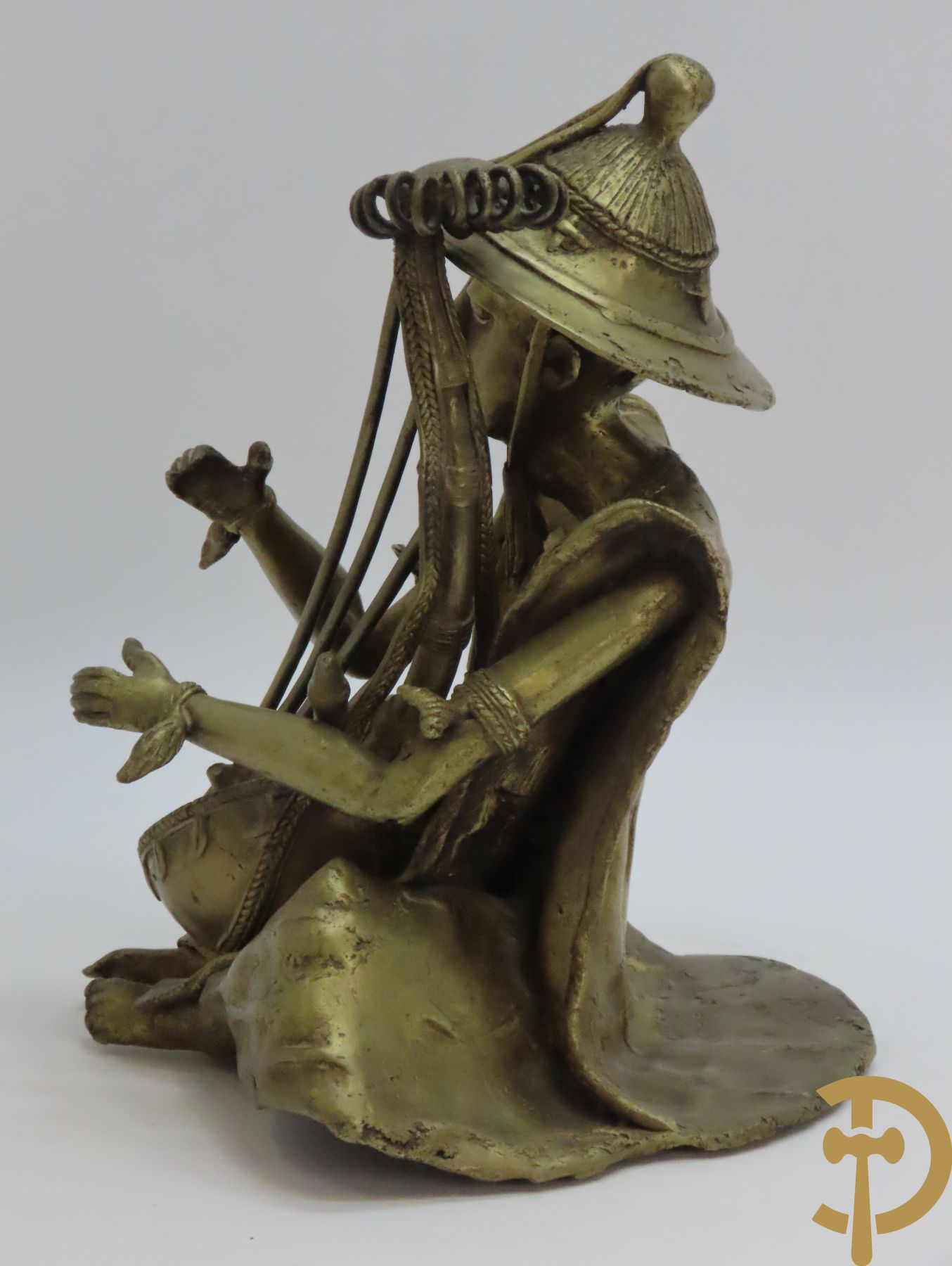 Balinese bronssculptuur van zittende man met snaarinstrument