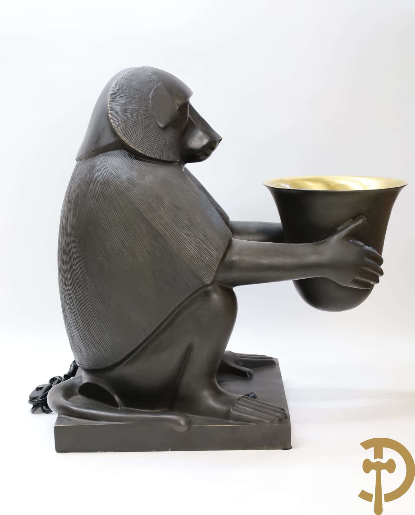 Gestyleerde zittende aap in brons houdende een kelk met lamp