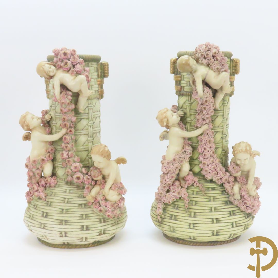 Paar meerkleurige faience vazen,  Austria gemerkt, met cupido's dragende bloemenranken
