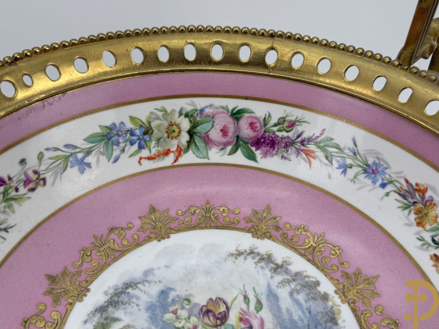 Porseleinen coupe met centraal tafereel en omringd met bloemendecor, gevat in bronzen houder