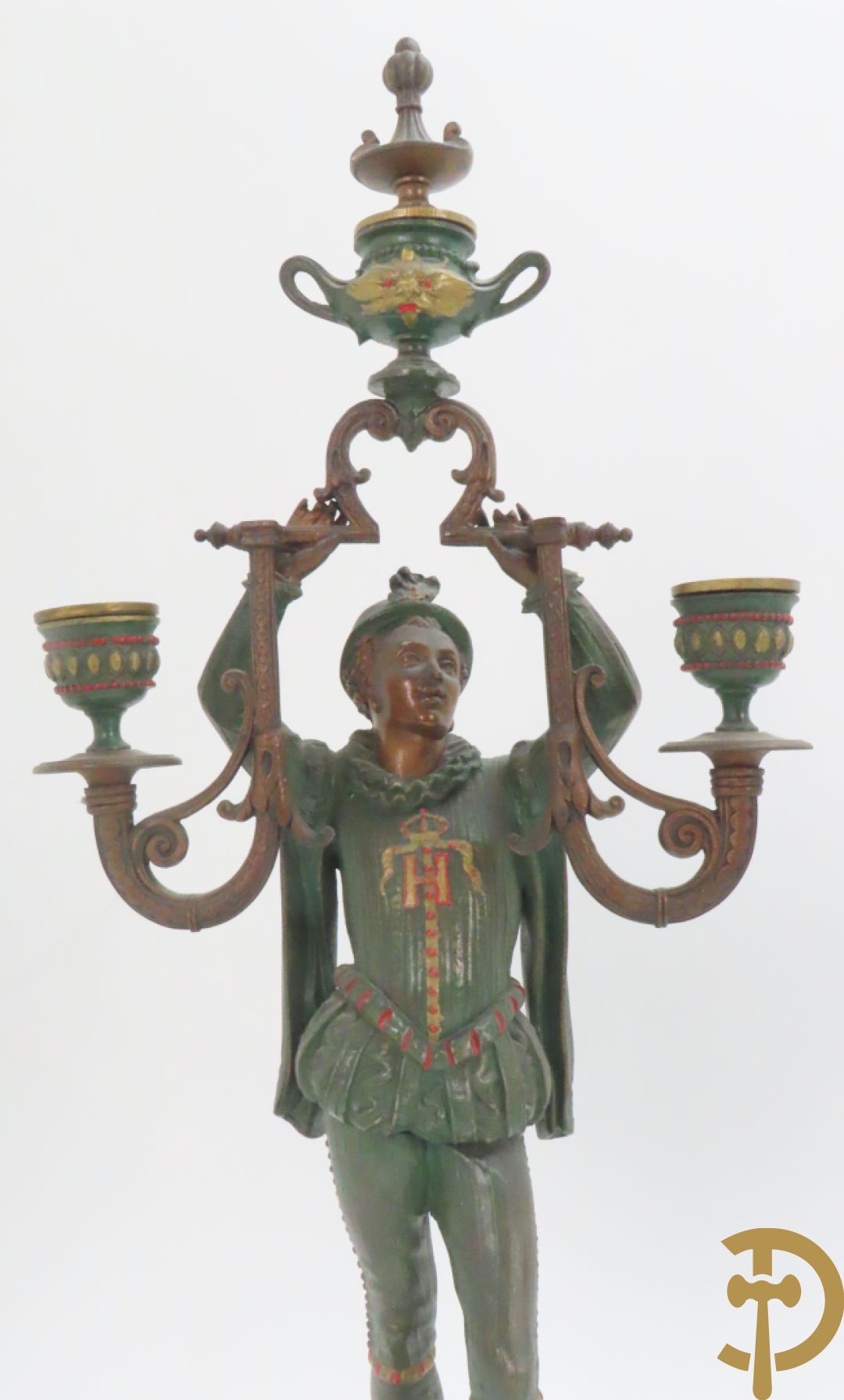 Driedelige kunstbronzen garnituur bestaande uit pendule met paar schakende edelheren, bezet met kariatiden - geflankeerd door paar driearmige kandelaars gehouden door 2 edelheren