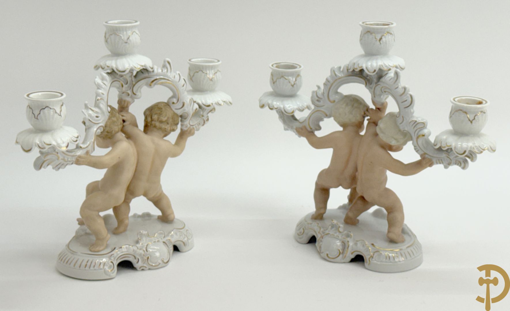 Twee kandelaars in biscuit met cupido