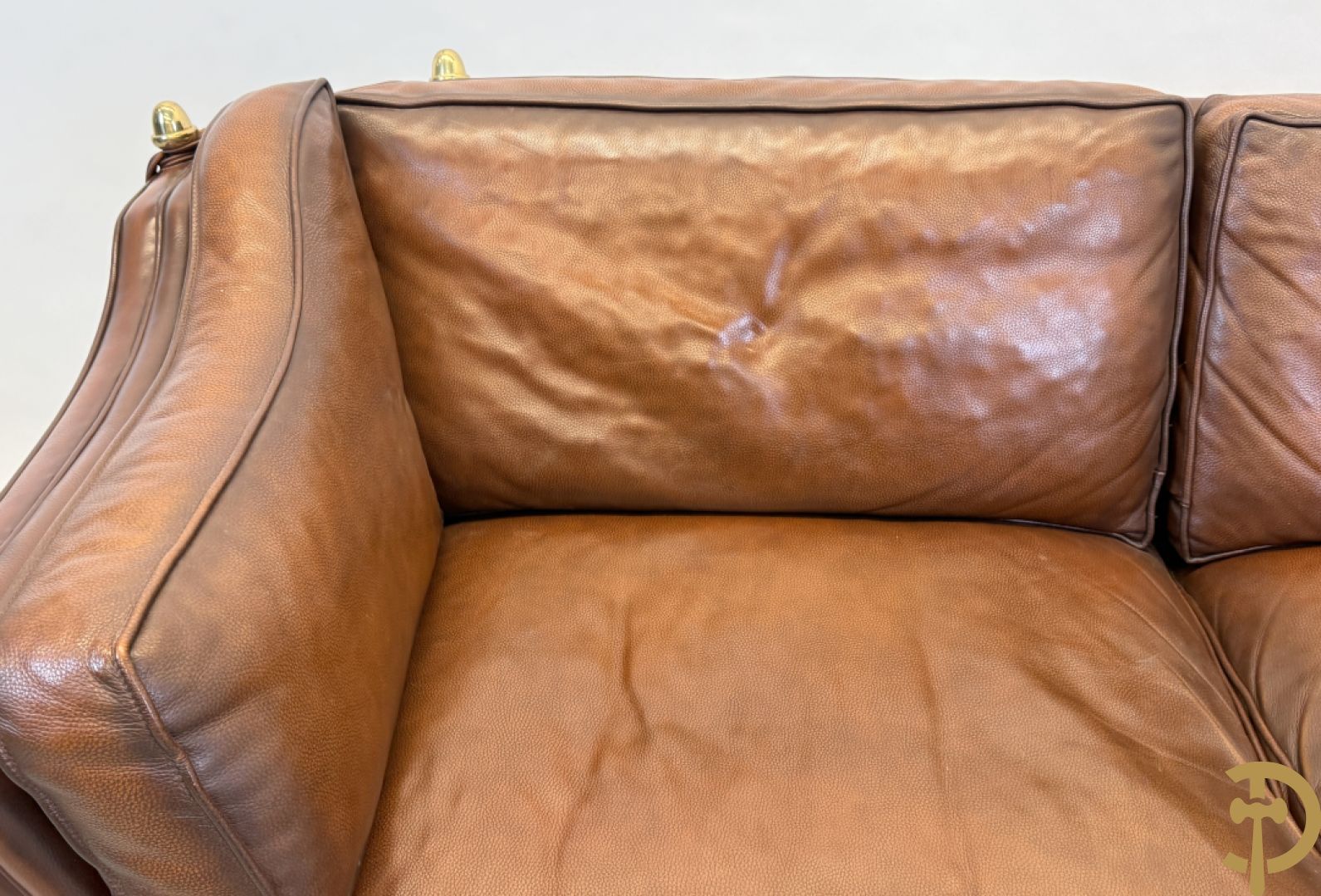 Bruin lederen canapé met kantelbare zijkanten en koperen denappels