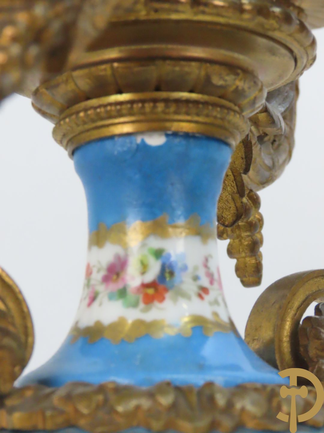 Driedelige bronzen garnituur bezet met Sèvres porselein bestaande uit pendule geflankeerd door paar cupido