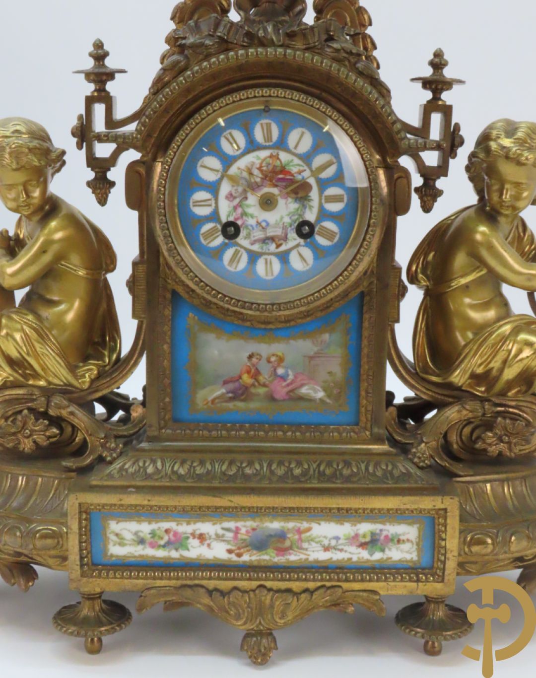 Driedelige bronzen garnituur bezet met Sèvres porselein bestaande uit pendule geflankeerd door paar cupido
